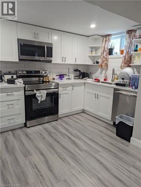 Kitchener apartment for rent - A room with a white chair and a table with a black tablecloth and some toys on the floor.