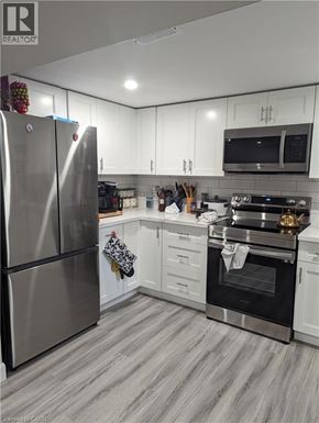 Kitchener apartment for rent - A kitchen with white cabinets and a stainless steel refrigerator.