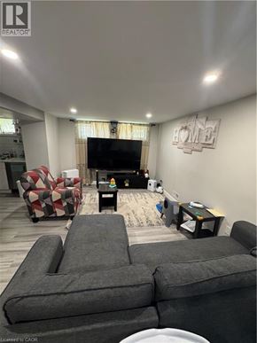 Kitchener apartment for rent - A living room with a grey sofa and a television.
