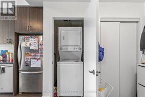 Oakville (Go Glenorchy) condo for rent - A kitchen with a refrigerator, oven, and a door leading to a laundry room.
