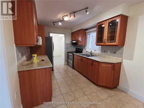 Vaughan (Crestwood-Springfarm-Yorkhill) apartment for rent - A kitchen with brown cabinets and a black refrigerator.