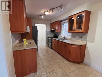 Vaughan (Crestwood-Springfarm-Yorkhill) apartment for rent - A kitchen with brown cabinets and a black refrigerator.