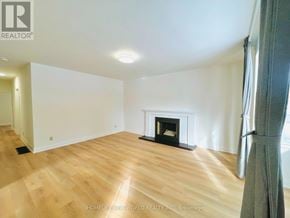 Toronto (Willowdale East) apartment for rent - A spacious room with a fireplace and wooden flooring.
