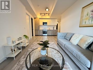 Toronto (Centennial Scarborough) condo for rent - A modern living room with a grey sofa and a glass coffee table.