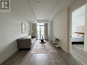 Toronto (Centennial Scarborough) condo for rent - A well-lit, spacious living room with a grey sofa and a rug in the center.