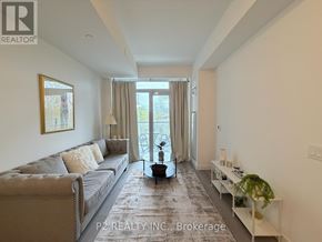 Toronto (Centennial Scarborough) condo for rent - A living room with a grey couch and a large window with curtains.