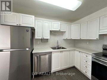 Mississauga (City Centre) condo for rent - A kitchen with white cabinets and a stainless steel refrigerator.