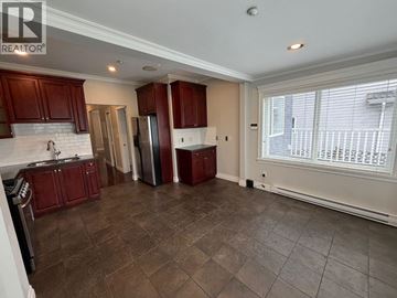 Vancouver apartment for rent - A kitchen with brown cabinets and a tiled floor.