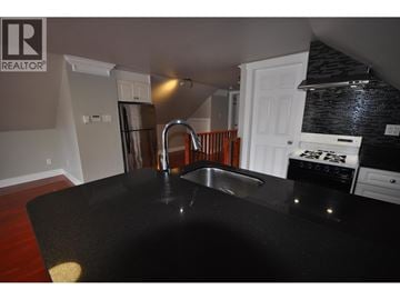Burnaby apartment for rent - A kitchen with a black counter top and a sink.