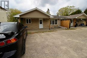 Guelph/Eramosa (Rockwood) fourplex for rent - A black car is parked in a driveway in front of a house.