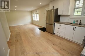 Guelph/Eramosa (Rockwood) fourplex for rent - A kitchen with wooden floors and white cabinets.