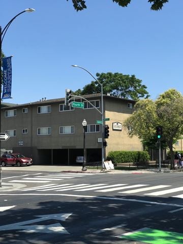 San Jose apartment for rent - A street corner with a traffic light and a building in the background.