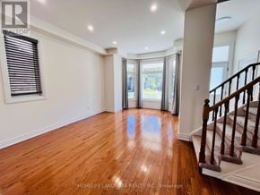 Markham (Cornell) apartment for rent - A spacious room with wooden floors and a staircase on the right side.