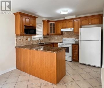 Newmarket (Woodland Hill) apartment for rent - A kitchen with wooden cabinets and a granite countertop.