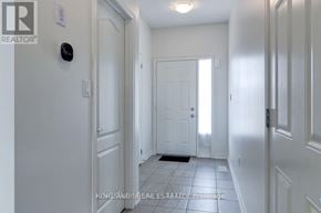 Hamilton (Stoney Creek Mountain) townhouse for rent - A hallway with a door at the end and a Realty logo on the wall.