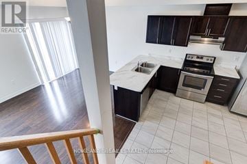 Hamilton (Stoney Creek Mountain) townhouse for rent - A modern kitchen with dark wood cabinets and stainless steel appliances.