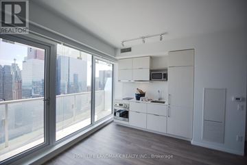 Toronto (Church-Yonge Corridor) condo for rent - A modern kitchen with white cabinets and a view of the city.