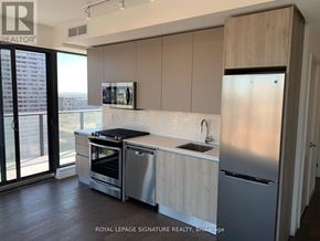 Toronto (Waterfront Communities) condo for rent - A modern kitchen with stainless steel appliances and wooden cabinets.