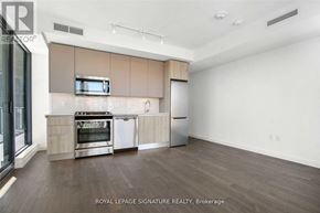 Toronto (Waterfront Communities) condo for rent - A kitchen with a stove top oven and a microwave above it.