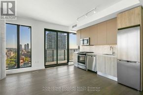 Toronto (Waterfront Communities) condo for rent - A modern kitchen with wooden floors and stainless steel appliances.