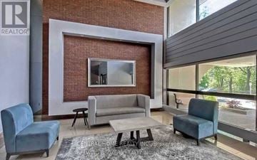 Toronto (Don Valley Village) condo for rent - A living room with a grey couch and a white coffee table.