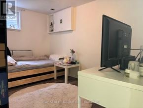 Toronto (Pleasant View) apartment for rent - A bedroom with a bed, a small table, and a television.