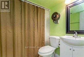 Toronto (Pleasant View) apartment for rent - A small bathroom with a toilet, sink and shower curtain.