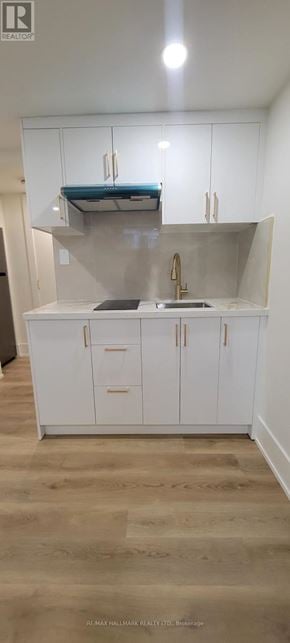 Aurora (Aurora Highlands) apartment for rent - A kitchen with white cabinets and a wooden floor.