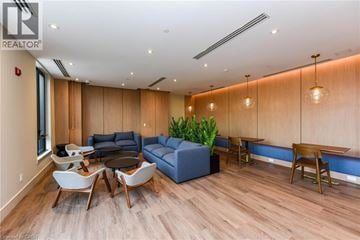 Milton condo for rent - A living room with a blue couch and wooden floors.
