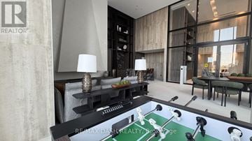 Vaughan (Steeles West Industrial) condo for rent - A modern living room with a pool table in the center.