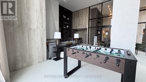 Vaughan (Steeles West Industrial) condo for rent - A foosball table is in the middle of a room with a REALTOR sign on the wall.