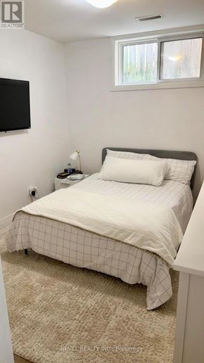 Toronto (Keelesdale-Eglinton West) apartment for rent - A bedroom with a bed, a nightstand, and a window.