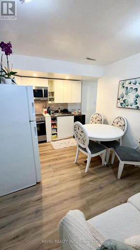 Toronto (Keelesdale-Eglinton West) apartment for rent - A white refrigerator is in a kitchen with a table and chairs.