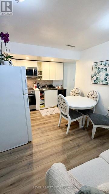 Toronto (Keelesdale-Eglinton West) apartment for rent - A white refrigerator is in a kitchen with a table and chairs.