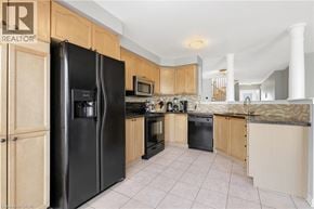 Oakville townhouse for rent - A kitchen with black appliances and wooden cabinets.