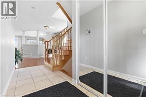 Oakville townhouse for rent - A hallway with a black doormat and a wooden staircase.
