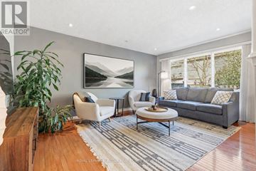 Oakville (Wm Westmount) townhouse for rent - A living room with a grey couch, a white chair, a wooden coffee table and a painting on the wall.