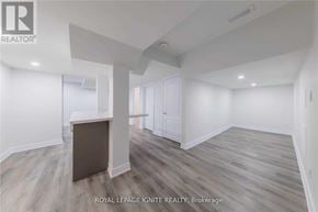Clarington (Bowmanville) apartment for rent - A spacious room with wooden flooring and white walls.