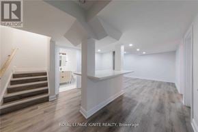 Clarington (Bowmanville) apartment for rent - A spacious room with wooden flooring and white walls.