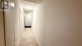 Oshawa (Windfields) condo for rent - A long hallway with a black rug on the floor.