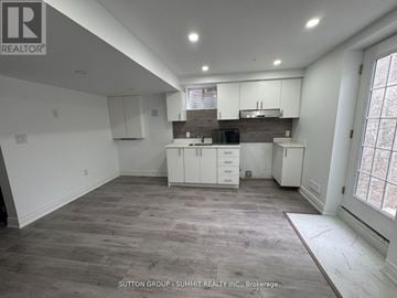 Milton (Co Coates) apartment for rent - A spacious kitchen with white cabinets and a wooden countertop.