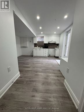 Milton (Co Coates) apartment for rent - A spacious kitchen with white cabinets and a wooden floor.