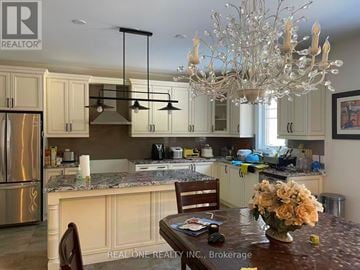 Aurora apartment for rent - A kitchen with a table and chairs in the foreground and a chandelier hanging from the ceiling.