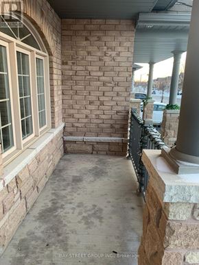 Markham (Wismer) townhouse for rent - A patio area with a brick wall and a window.