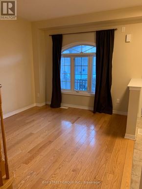Markham (Wismer) townhouse for rent - A room with a wooden floor and a window with curtains.