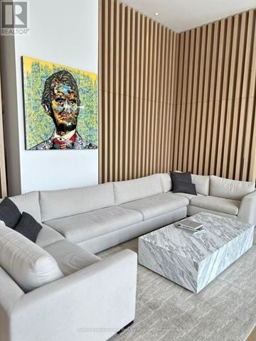 Mississauga (Cooksville) condo for rent - A living room with a white couch and a painting of a man on the wall.