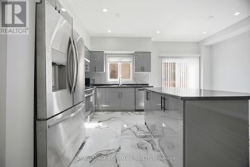 Mississauga (Churchill Meadows) apartment for rent - A modern kitchen with stainless steel appliances and a marble countertop.