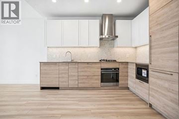 Burnaby apartment for rent - A modern kitchen with wooden cabinets and a stainless steel range hood.