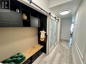 Toronto (Regent Park) condo for rent - A hallway with a bench and a wall with a geometric pattern.