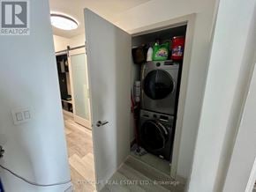Toronto (Regent Park) condo for rent - A laundry room with a washer and dryer in a small cabinet.